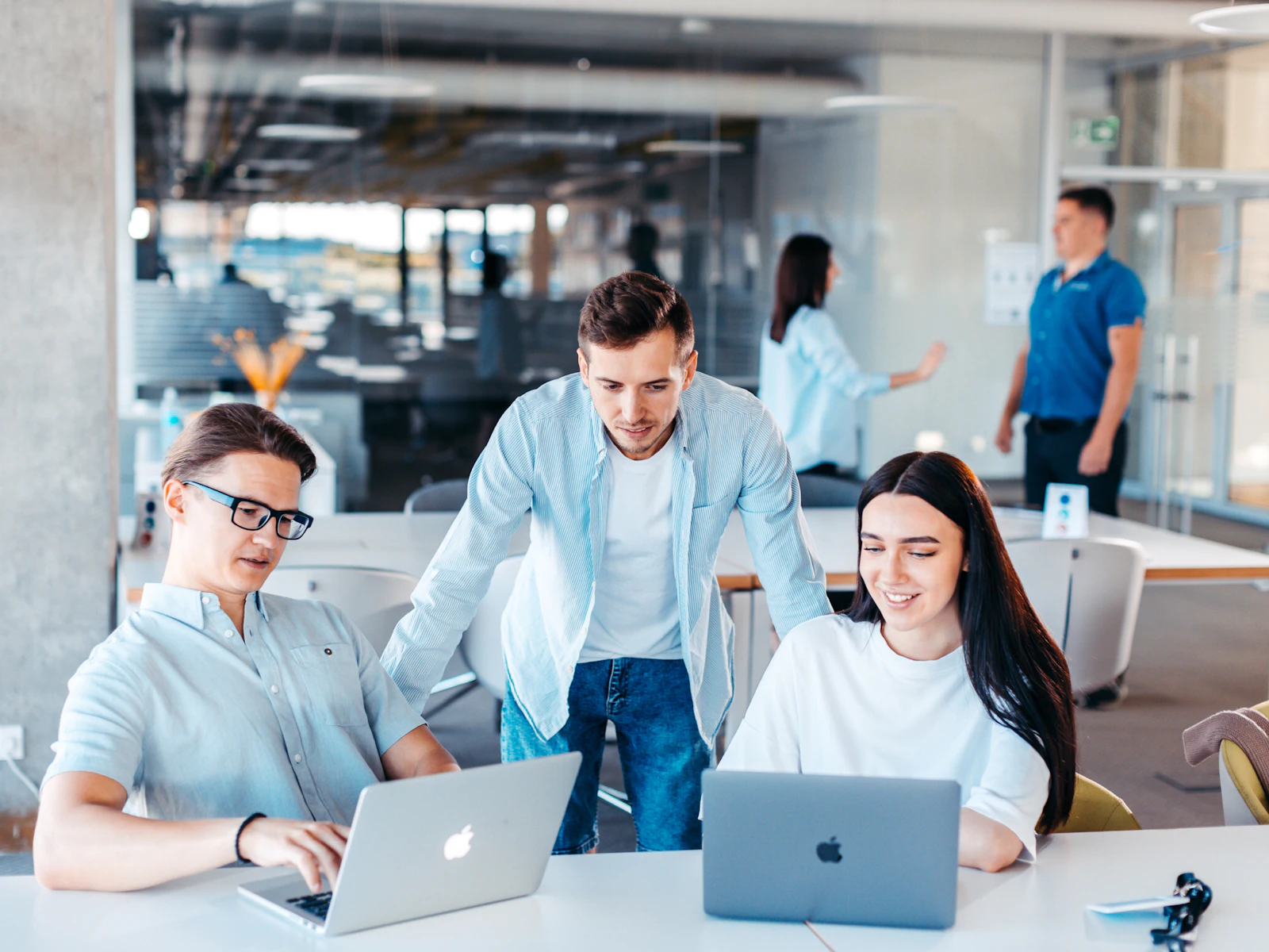 Team collaborating on laptops in a modern office